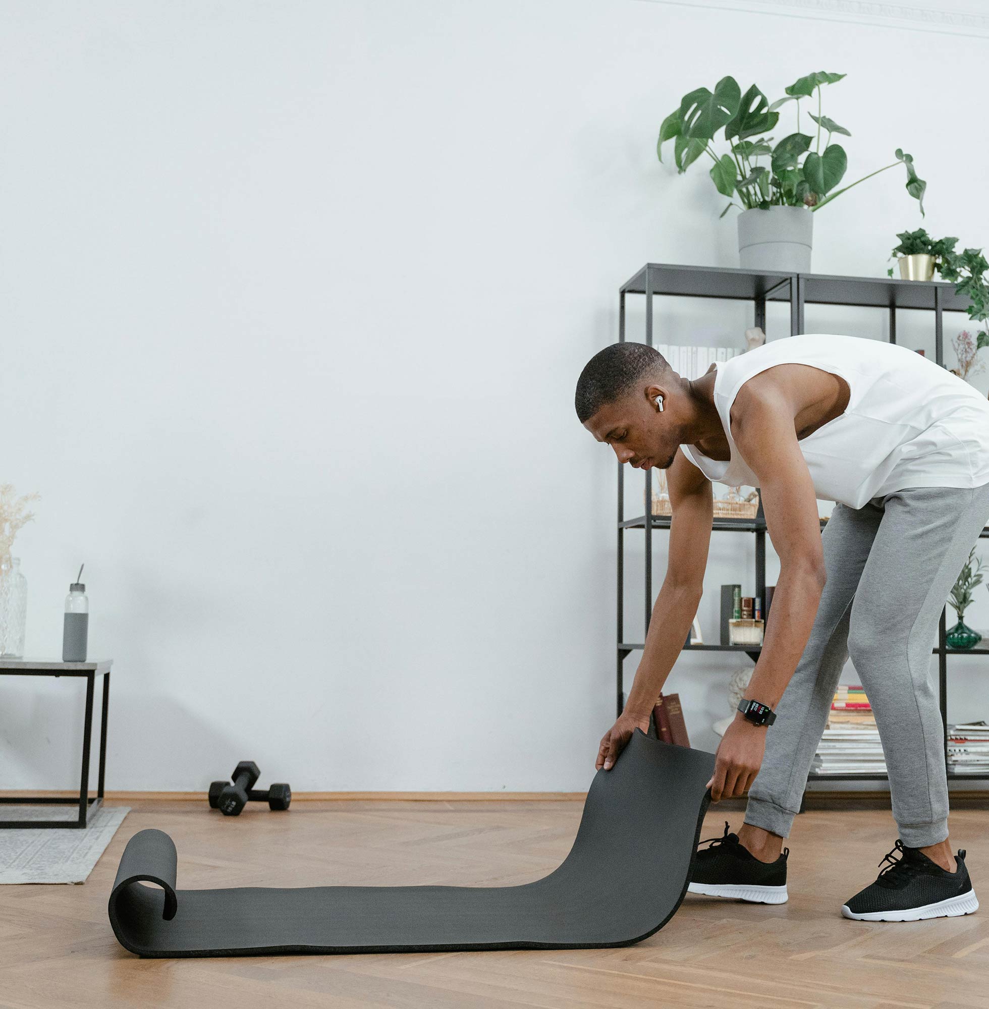 Man Rolling Out a Gym Mat to Exercise