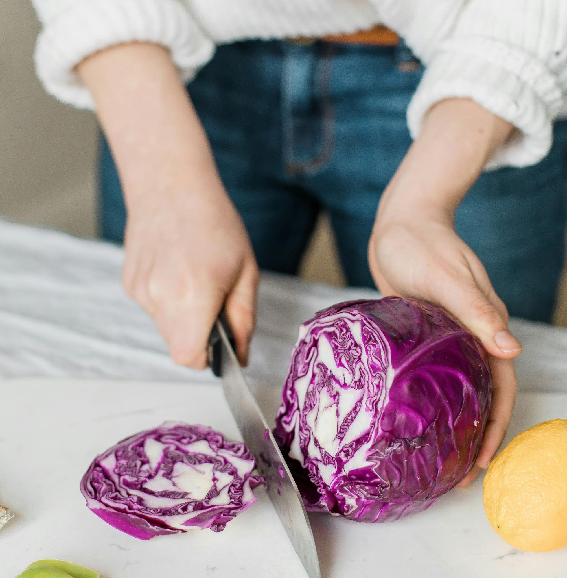 Woman Cutting a Red Cabbage on a Cutting Board